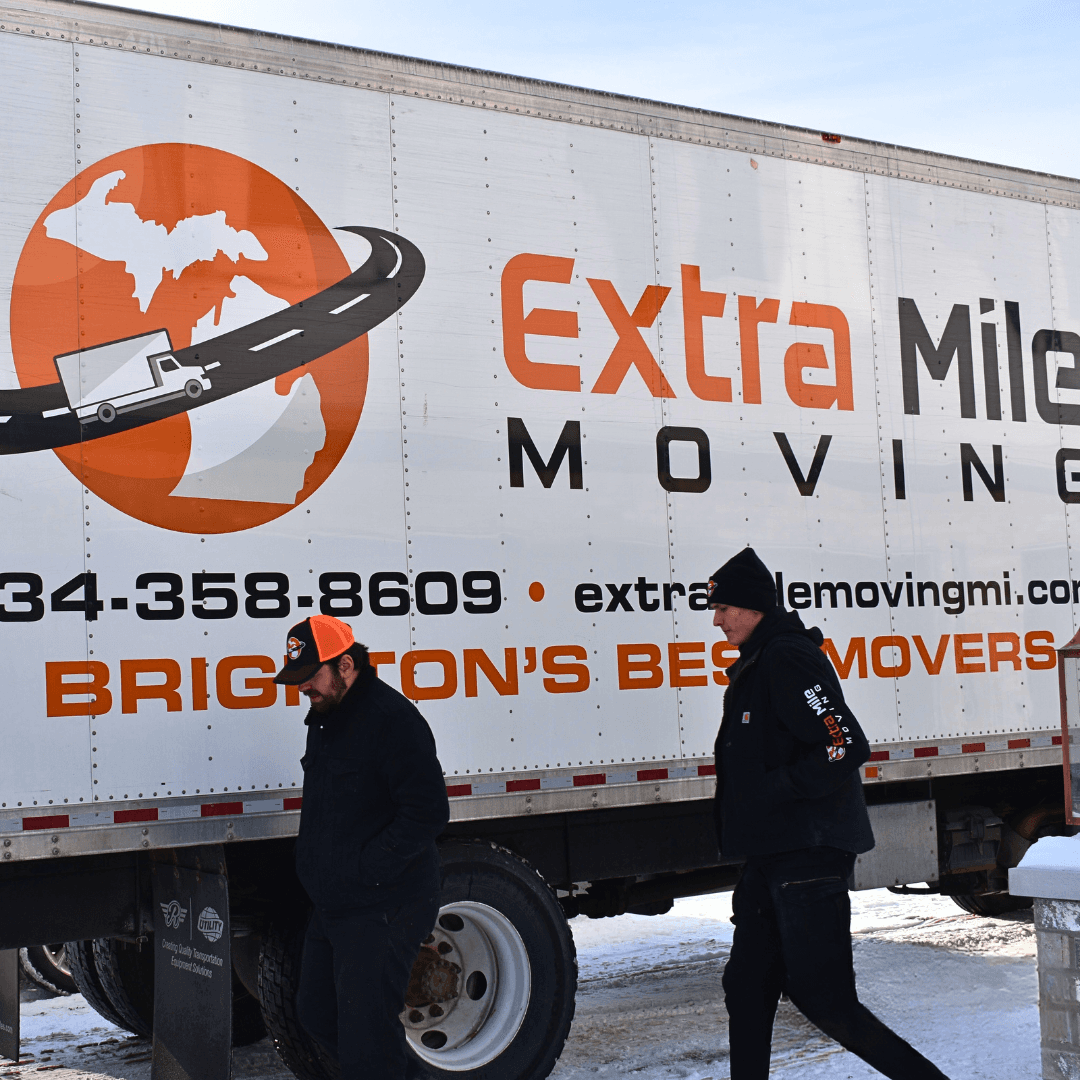 Extra Mile Moving crew walking in front of a moving truck